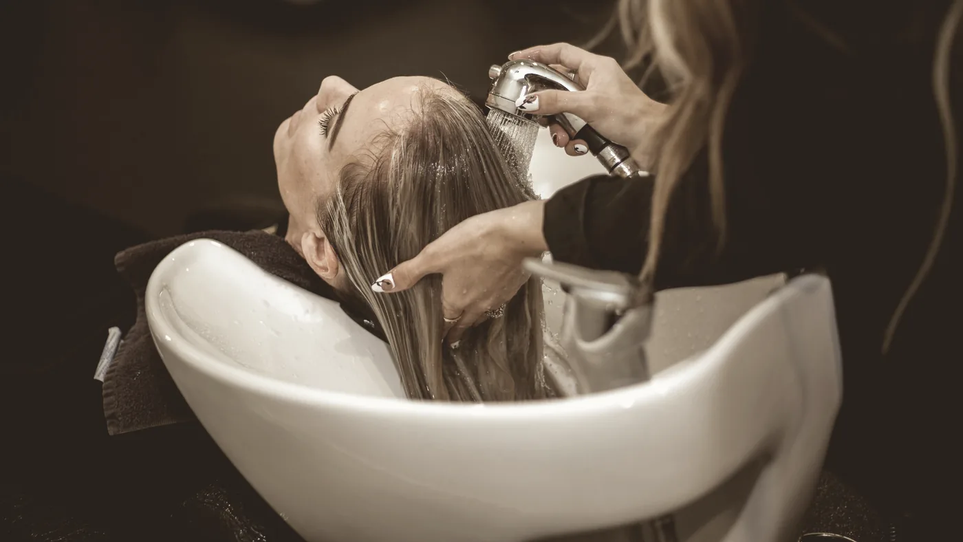 Håret sköljs igenom i salongens tvättstol